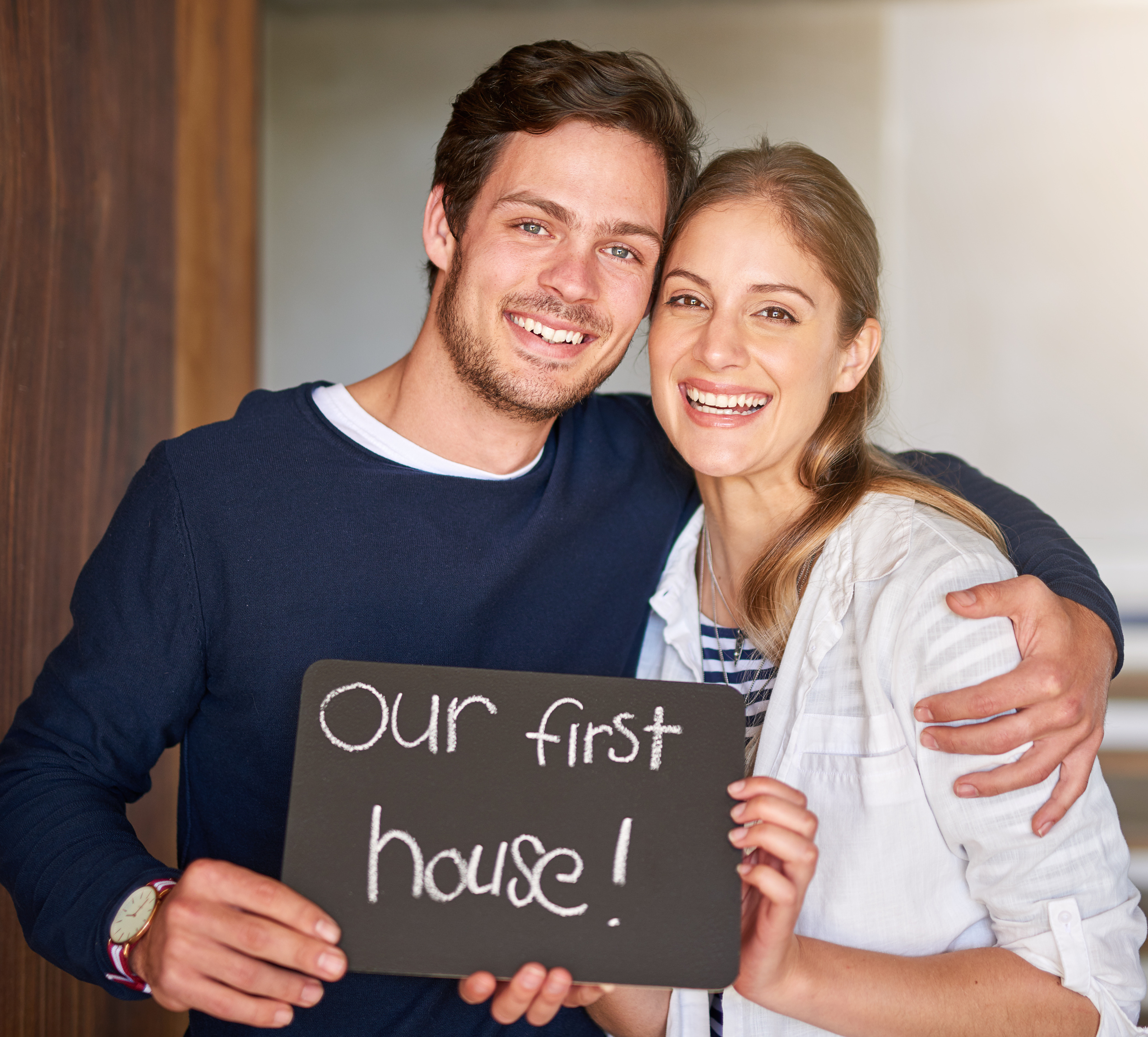 happy-couple-holding-sign-moving-new-house.jpg